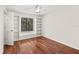 Bedroom with hardwood floors, white built-in shelving, and sun-filled window with blinds at 530 Estates Pl, Longwood, FL 32779