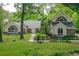 Charming home featuring a lush green lawn, mature trees, and unique architectural details at 530 Estates Pl, Longwood, FL 32779
