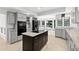 Gourmet kitchen with granite counters, black appliances, dark island and light grey cabinets at 530 Estates Pl, Longwood, FL 32779