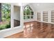 Bright living room featuring hardwood floors, built-in shelves, and large windows offering scenic outdoor views at 530 Estates Pl, Longwood, FL 32779