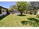 Large backyard with a tree providing shade and a screened-in pool at 75 Knollwood Estates Dr, Ormond Beach, FL 32174
