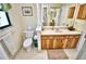 Bright bathroom featuring a toilet and vanity with wood-grain cabinets and neutral countertops at 75 Knollwood Estates Dr, Ormond Beach, FL 32174