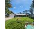 Charming single-story home with well-manicured lawn and an inviting, covered porch with a screened in pool in the bottom corner at 75 Knollwood Estates Dr, Ormond Beach, FL 32174
