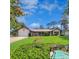 Charming single-story home featuring a well-kept lawn, attractive landscaping, and a delightful screened-in pool area at 75 Knollwood Estates Dr, Ormond Beach, FL 32174