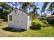 Backyard shed is accented with decorative windows and surrounded by greenery at 75 Knollwood Estates Dr, Ormond Beach, FL 32174