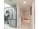 Hallway view to kitchen with stainless refrigerator and white tile flooring at 2967 S Atlantic Ave # 708, Daytona Beach Shores, FL 32118