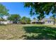 Spacious backyard with a lush lawn, mature trees, shed, and a screened-in porch for outdoor living at 394 Golf Blvd, Daytona Beach, FL 32118