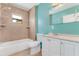 Bathroom featuring a tub with shower, white vanity, and turquoise walls for a clean and modern feel at 394 Golf Blvd, Daytona Beach, FL 32118