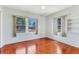 Bedroom featuring hardwood floors, neutral walls, and two windows offering natural light and outdoor views at 394 Golf Blvd, Daytona Beach, FL 32118