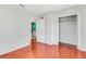 Bedroom with hardwood floors, closet space, and an open door leading to a bathroom with blue walls at 394 Golf Blvd, Daytona Beach, FL 32118