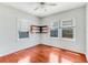 Corner bedroom showcasing hardwood floors, built-in shelving, and two windows offering outdoor views and natural light at 394 Golf Blvd, Daytona Beach, FL 32118