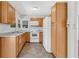Functional kitchen with wood cabinets and white appliances, providing a practical space for cooking and meal preparation at 394 Golf Blvd, Daytona Beach, FL 32118