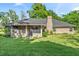 Charming brick home featuring a lush green lawn, screened porch, and brick chimney at 4008 Acoma Dr, Ormond Beach, FL 32174