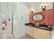 Well-lit bathroom featuring a double sink vanity with granite countertops and red brick backsplash at 4008 Acoma Dr, Ormond Beach, FL 32174