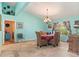 Light-filled dining room with travertine tile, chandelier, and colorful decor showcasing the home's unique character at 4008 Acoma Dr, Ormond Beach, FL 32174