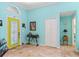 Inviting foyer featuring tile flooring, a bright yellow door, and ample natural light at 4008 Acoma Dr, Ormond Beach, FL 32174