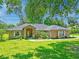 Beautiful one story home with mature trees and a green lawn in a serene setting at 4008 Acoma Dr, Ormond Beach, FL 32174