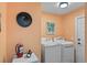Laundry room with side-by-side washer and dryer, neutral walls and a fire extinguisher at 4008 Acoma Dr, Ormond Beach, FL 32174
