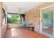 Enclosed porch with brick accents, tile flooring and ceiling fan, perfect for outdoor relaxation and shade at 4008 Acoma Dr, Ormond Beach, FL 32174