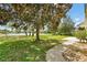 Scenic backyard featuring mature tree, landscaped path, view of the green space, and pond at 518 Moon Rise Dr, Port Orange, FL 32127