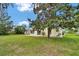 Spacious backyard with mature tree, lawn, screened-in patio, and a well-maintained exterior at 518 Moon Rise Dr, Port Orange, FL 32127
