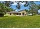 Back view of home showcasing the big backyard, screened-in patio, and the house's design at 518 Moon Rise Dr, Port Orange, FL 32127