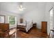 Bedroom with wood floors, a ceiling fan, a window with a view of trees, and a wooden bed frame at 518 Moon Rise Dr, Port Orange, FL 32127