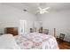 Bright bedroom with a floral quilt, hardwood floors, and ceiling fan at 518 Moon Rise Dr, Port Orange, FL 32127