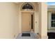 Elegant front entryway with a decorative light fixture, neutral-colored door, and sidelight window at 518 Moon Rise Dr, Port Orange, FL 32127