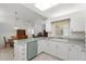 Kitchen with light countertops, white cabinets, stainless steel dishwasher and a dining area to the right at 518 Moon Rise Dr, Port Orange, FL 32127