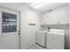 Functional laundry room with modern washer, dryer, and built-in cabinets at 518 Moon Rise Dr, Port Orange, FL 32127