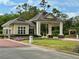 Community entrance featuring a guard house, portico, brick-paved walkway, and manicured landscaping at 745 Aldenham Ln, Ormond Beach, FL 32174