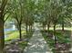 A peaceful park with a gazebo, walking path lined with trees, and a fountain in the lake at 745 Aldenham Ln, Ormond Beach, FL 32174