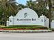 A Plantation Bay entrance sign surrounded by lush greenery and colorful flowers, creating a welcoming atmosphere at 745 Aldenham Ln, Ormond Beach, FL 32174