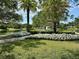 Scenic view of a white gazebo in a park-like setting with a pond and lush greenery at 745 Aldenham Ln, Ormond Beach, FL 32174