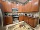 This is a kitchen with stainless steel appliances, wooden cabinets, and tile flooring at 745 Aldenham Ln, Ormond Beach, FL 32174