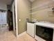 Well-organized laundry room with modern washer, dryer, and shelving for efficient storage at 745 Aldenham Ln, Ormond Beach, FL 32174
