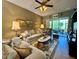 Comfortable living room with plush seating, ceiling fan, and sliding glass doors to the lanai at 745 Aldenham Ln, Ormond Beach, FL 32174