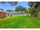 Spacious backyard featuring a screened-in pool enclosure, complemented by a well-kept lawn and tropical landscaping at 11 Larisa Ter, Ormond Beach, FL 32174