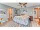 Light-filled bedroom with modern floors, patterned rug, ceiling fan, and ensuite bathroom at 11 Larisa Ter, Ormond Beach, FL 32174