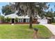 Inviting one-story home with a brick facade, lush green lawn, and mature landscaping for a serene aesthetic at 11 Larisa Ter, Ormond Beach, FL 32174