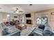 Cozy living room featuring stone fireplace, ceiling fan, and views of the outdoor pool at 11 Larisa Ter, Ormond Beach, FL 32174