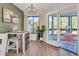 Bright dining area features a stylish chandelier, a bar-height table, and sliding doors to a sunroom at 133 Blue Heron Dr # C, Daytona Beach, FL 32119