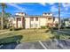 View of well-maintained townhouse exterior with a green lawn, trees, and blue sky at 133 Blue Heron Dr # C, Daytona Beach, FL 32119
