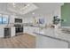 Well-lit kitchen featuring white cabinets, granite countertops, and stainless steel appliances at 133 Blue Heron Dr # C, Daytona Beach, FL 32119