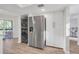 Kitchen area with modern stainless steel refrigerator, white cabinets, and laundry closet at 133 Blue Heron Dr # C, Daytona Beach, FL 32119