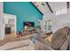 Open-concept living room featuring a high ceiling, wood beams, and an eye-catching teal accent wall at 133 Blue Heron Dr # C, Daytona Beach, FL 32119