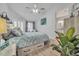 Bright main bedroom featuring a ceiling fan, a plant, and an ensuite bathroom in the background at 133 Blue Heron Dr # C, Daytona Beach, FL 32119