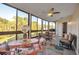 Bright sunroom with floor-to-ceiling windows, a ceiling fan, and a cozy seating area at 133 Blue Heron Dr # C, Daytona Beach, FL 32119