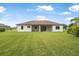 Expansive backyard showing the home's exterior with a screened lanai and ample green space at 1357 Liam Cir, Ormond Beach, FL 32174